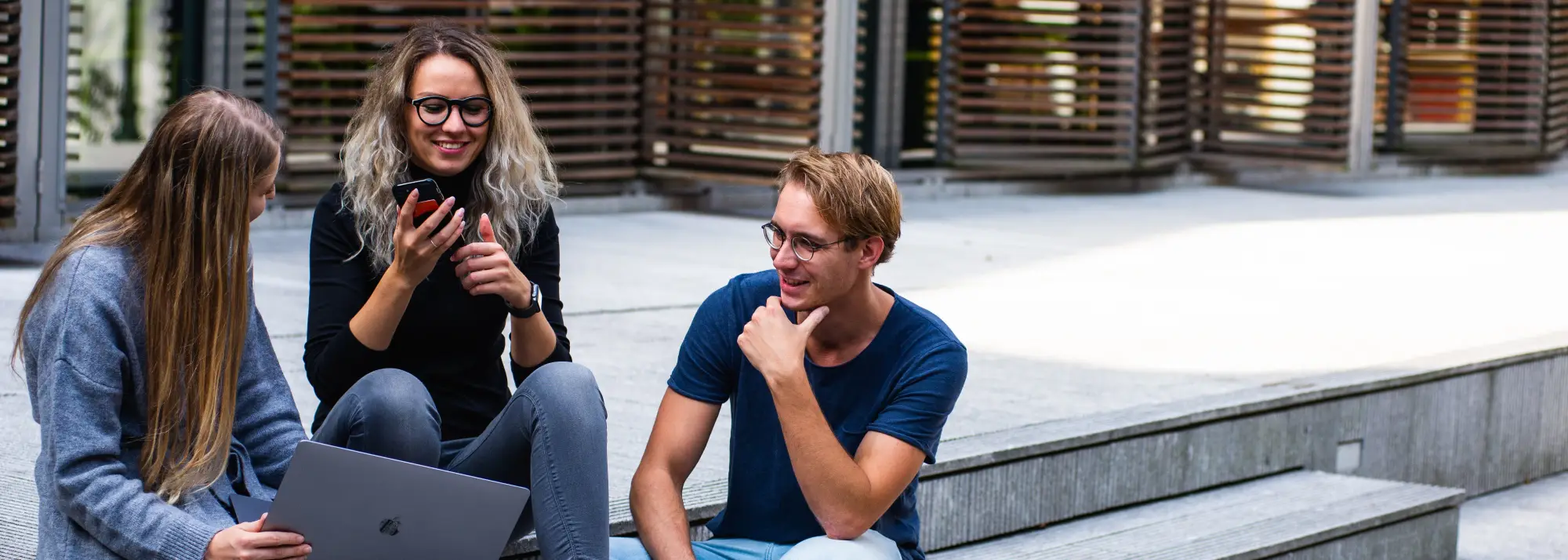 students-sitting-on-stairs-with-mobiles.webp